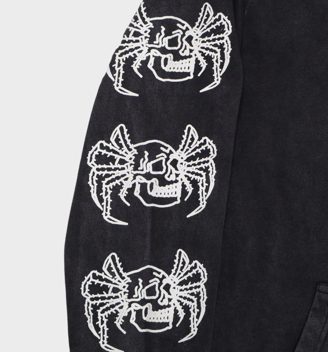 Close-up of hand-drawn spider and skull design on hoodie sleeve close