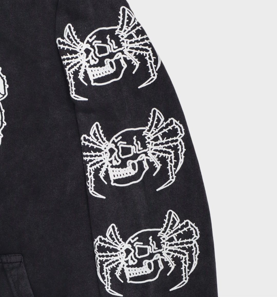 Close-up of hand-drawn spider and skull design on hoodie sleeve close up right
