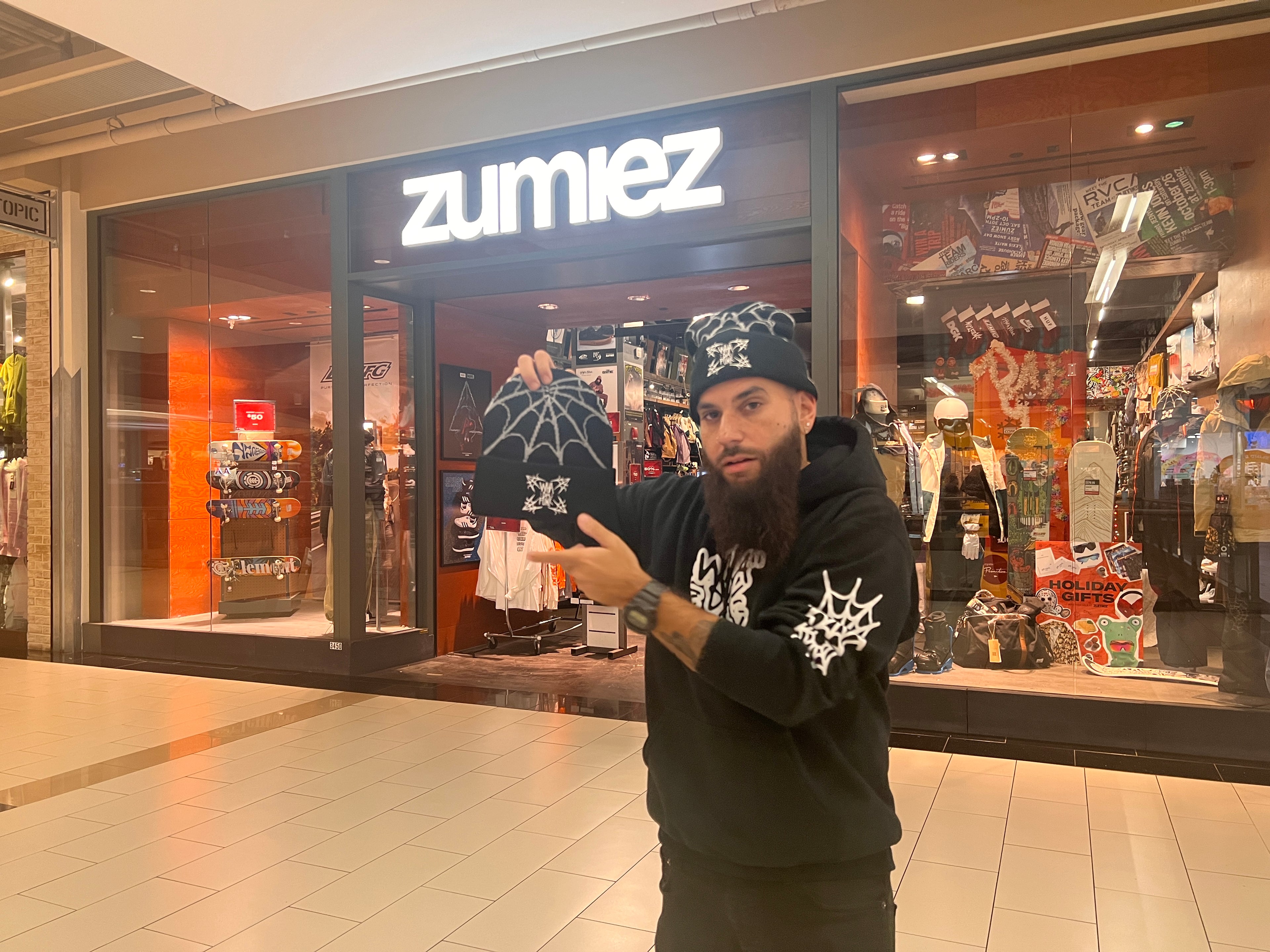 john g whadafunk holding beanie outside of zumiez store