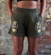 Load image into Gallery viewer, WHADAFUNK SKULL FACE WOMENS SHORTS MODEL WEARING HANDS IN POCKET

